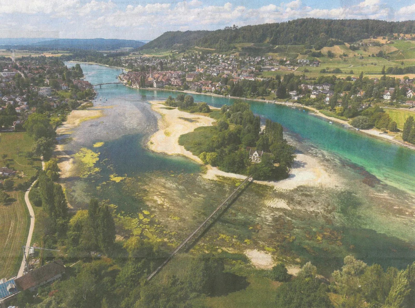 Luftaufnahme eines Flusslaufs bei Niedrigwasser: weite Kiesbänke und Sandflächen liegen trocken.